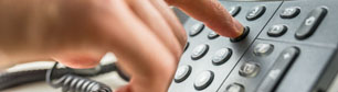 Ein Mitarbeiter wählt eine Telefonnummer auf einem Telefon leistungen-teaser-telefonanlagen.jpg